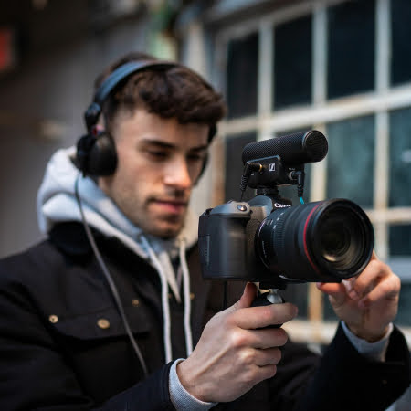 Person med kamera och Sennheiser MKE 400